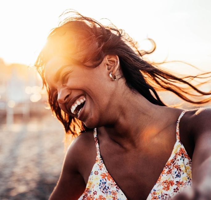 happy woman on beach in florida after ketamine treatment